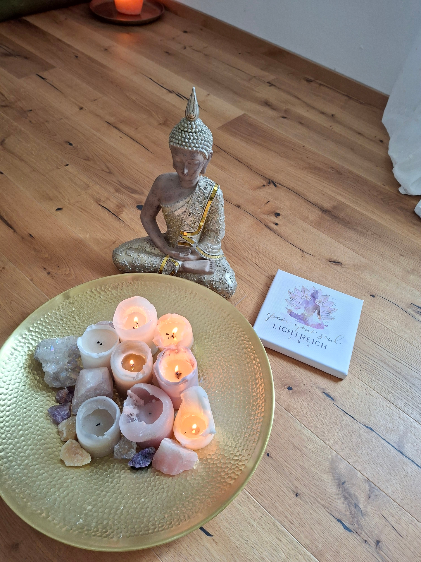 Kleiner Altar mit Kerzen, Kristallen und Buddha-Figur