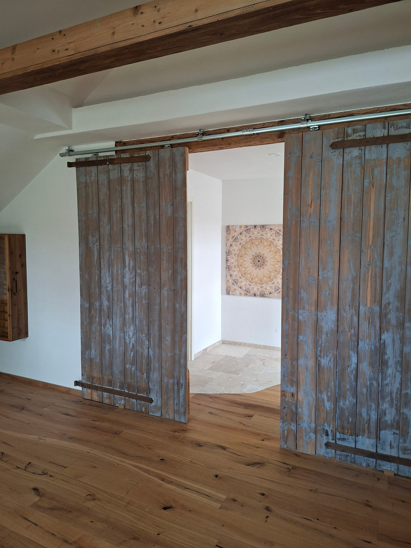 Alte Holz-Schiebetüren öffnen den Blick in den lichtvollen Praxisraum